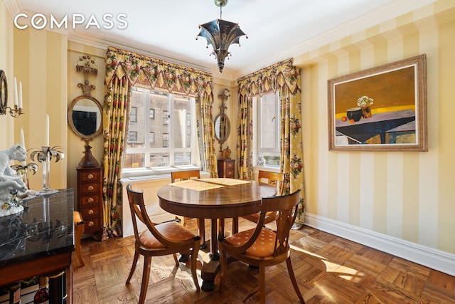 dining room with crown molding, baseboards, and wallpapered walls