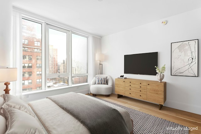 bedroom with baseboards and wood finished floors