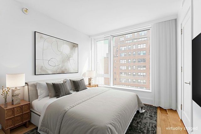 bedroom featuring multiple windows and light wood-style flooring