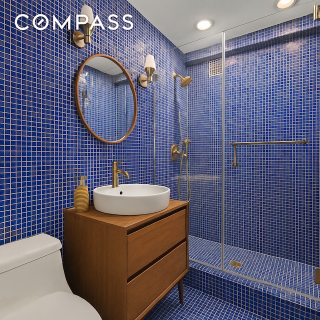 1025 5th Ave Unit 7As, New York City, NY 10028 - bathroom with tile walls, toilet, tile patterned floors, a tile shower, and vanity