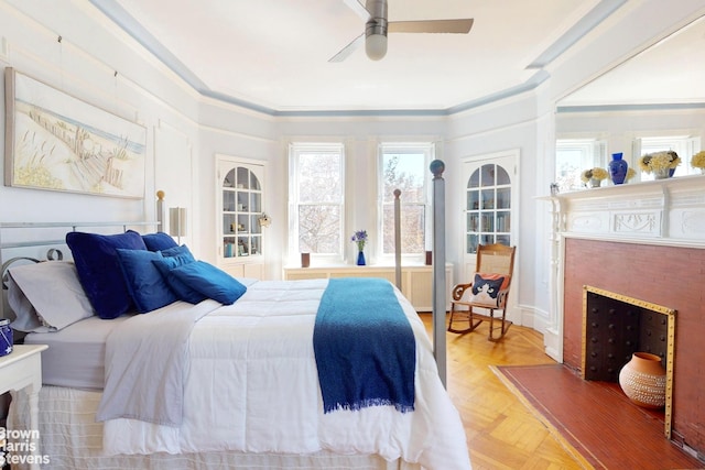 188 W 135th St Unit 5W, New York City, NY 10030 - bedroom with multiple windows, ornamental molding, a ceiling fan, and a fireplace with flush hearth