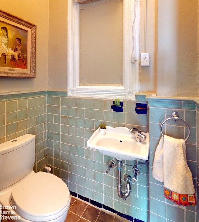 188 W 135th St Unit 5W, New York City, NY 10030 - half bath with tile walls, toilet, tile patterned flooring, wainscoting, and a sink