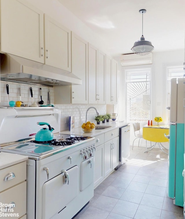 188 W 135th St Unit 5W, New York City, NY 10030 - kitchen featuring under cabinet range hood, dishwasher, freestanding refrigerator, light countertops, and tasteful backsplash