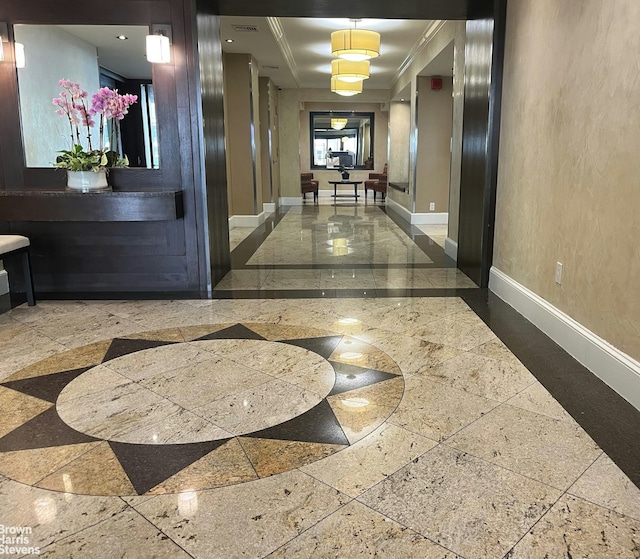 hallway featuring crown molding and baseboards