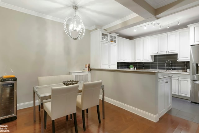 kitchen with stainless steel fridge with ice dispenser, beverage cooler, light countertops, white cabinets, and tasteful backsplash