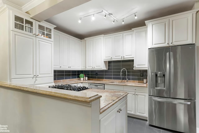 kitchen featuring a sink, appliances with stainless steel finishes, dark tile patterned floors, and white cabinetry