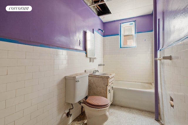 125 Stryker St, New York City, NY 11223 - bathroom with tile walls, a bathtub, tile patterned floors, vanity, and wainscoting