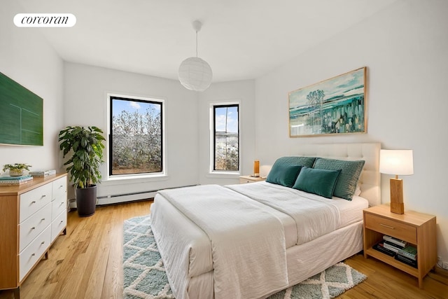 bedroom featuring light wood-style floors, baseboard heating, and visible vents