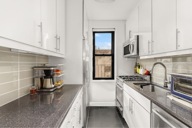 kitchen with a sink, tasteful backsplash, stainless steel appliances, and white cabinetry