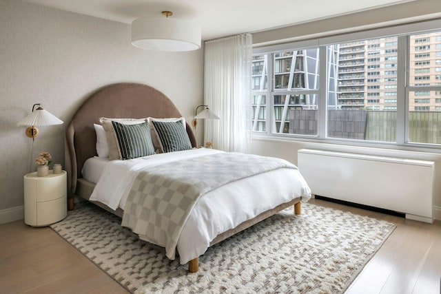 bedroom featuring radiator and wood finished floors