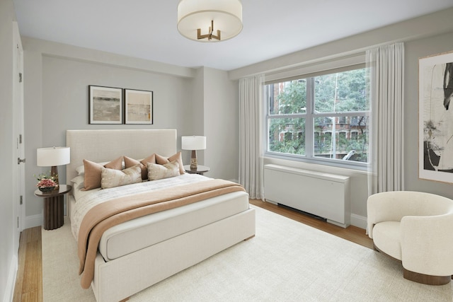 bedroom with wood finished floors and radiator