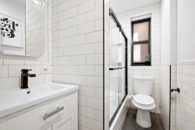 bathroom with vanity, an enclosed shower, toilet, and tile walls