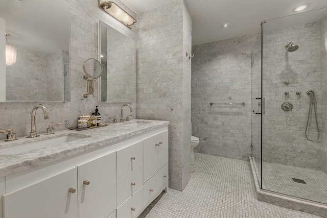 bathroom featuring tile walls, a sink, and a stall shower