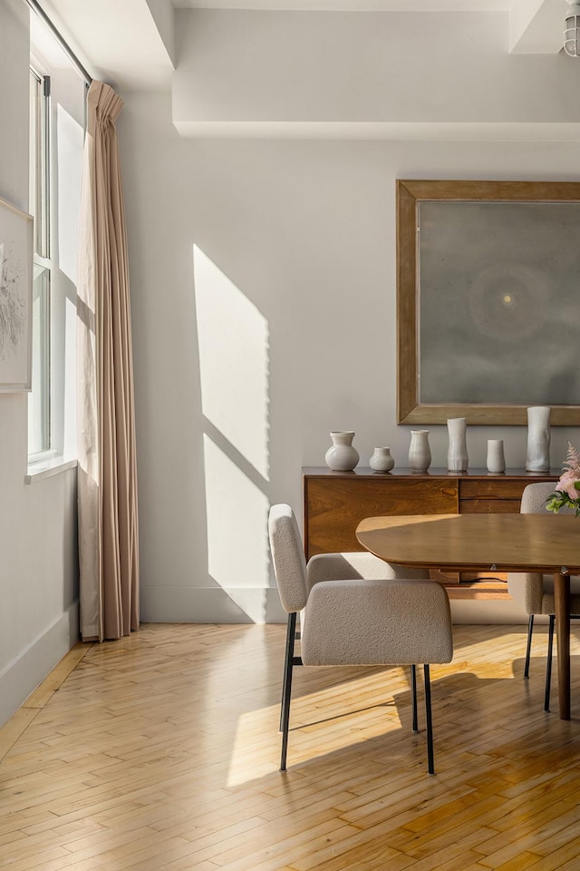 dining space featuring baseboards and light wood-style flooring