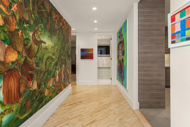 corridor with recessed lighting, baseboards, and wood finished floors