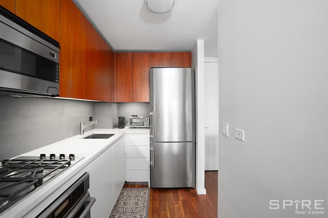 515 E 72nd St Unit 24A, New York City, NY 10021 - kitchen with stainless steel appliances, a sink, light countertops, dark wood-style floors, and modern cabinets