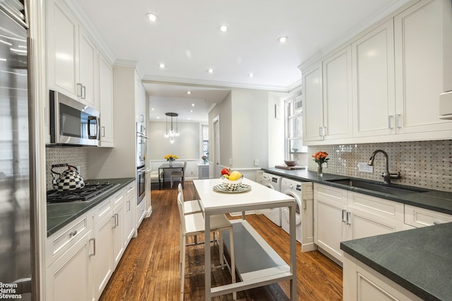 180 Riverside Dr Unit 3E, New York City, NY 10024 - kitchen with appliances with stainless steel finishes, dark countertops, dark wood-style flooring, recessed lighting, and ornamental molding