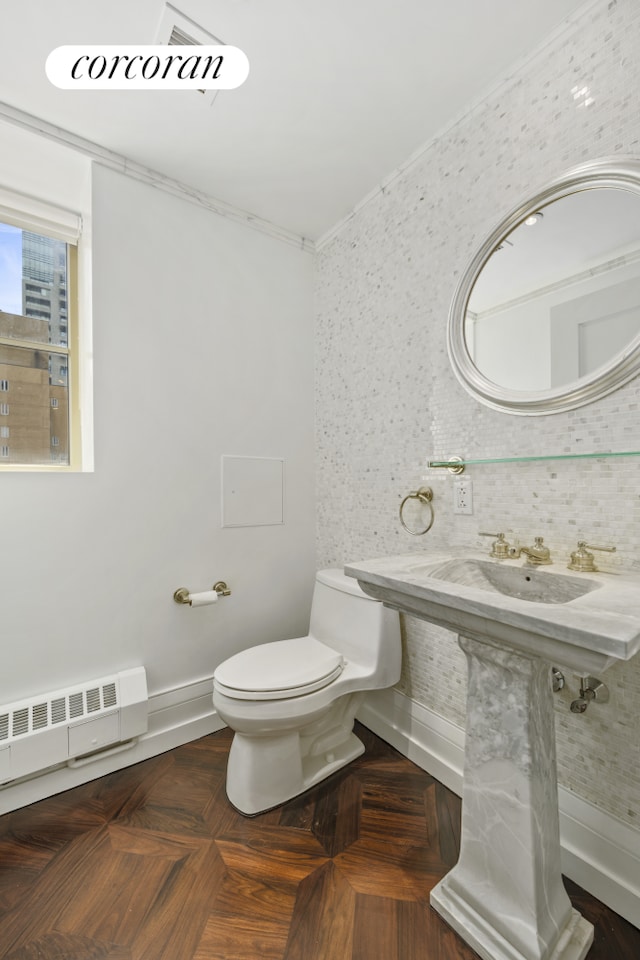 half bath featuring toilet, visible vents, ornamental molding, and radiator heating unit