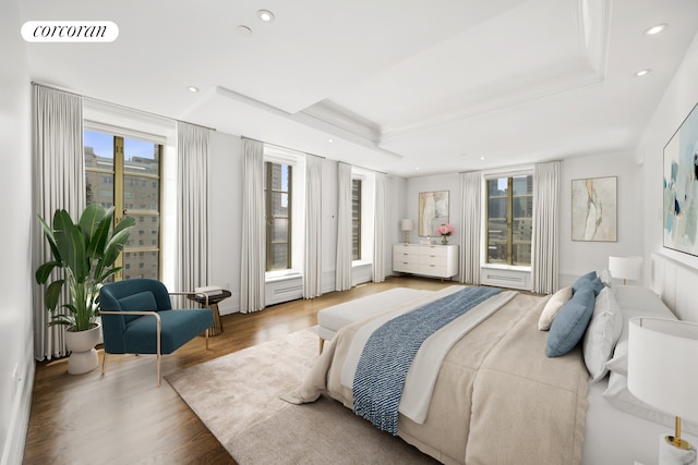 bedroom with recessed lighting, visible vents, wood finished floors, and a raised ceiling
