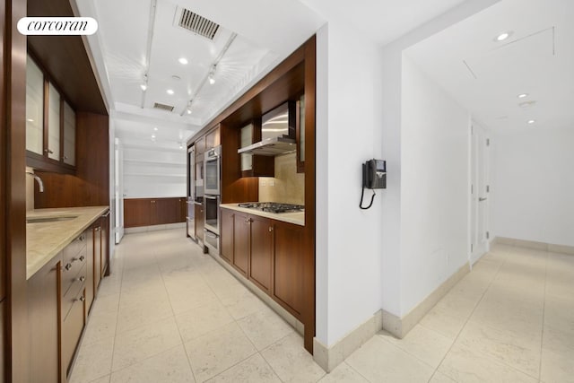 hall with visible vents, a sink, and light tile patterned floors