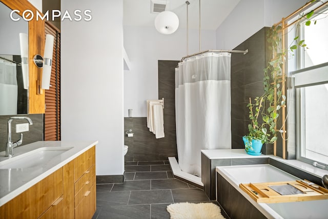 65 Jackson St, New York City, NY 11211 - full bath with a stall shower, vanity, a garden tub, tile patterned flooring, and tile walls
