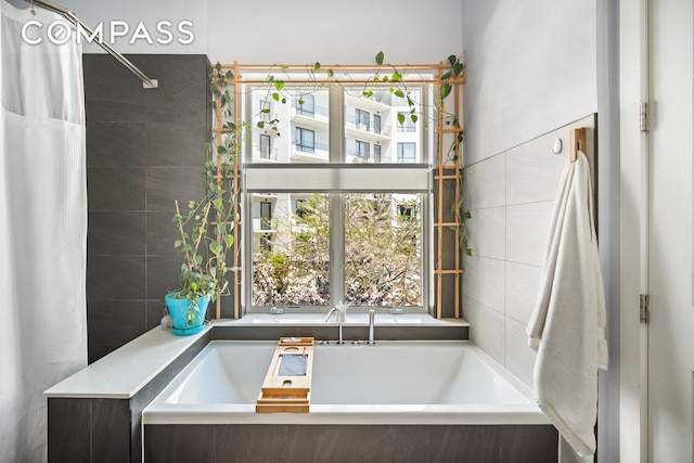 65 Jackson St, New York City, NY 11211 - bathroom featuring a garden tub, a shower with shower curtain, and tile walls