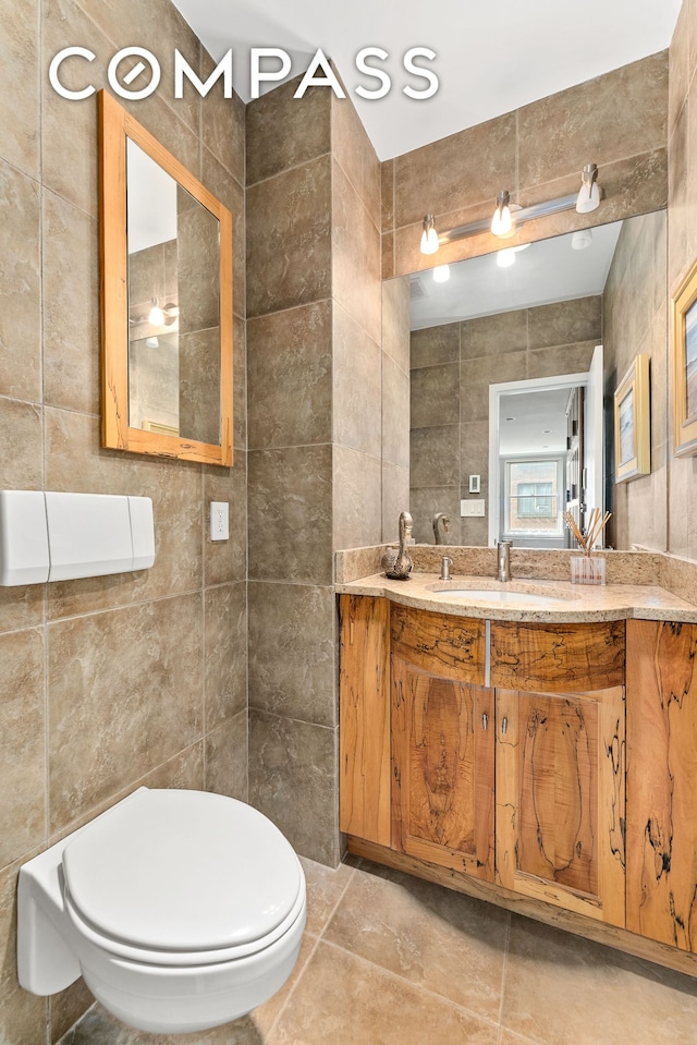112 E 83rd St Unit 6C, New York City, NY 10028 - bathroom featuring tile walls, vanity, toilet, and tile patterned flooring