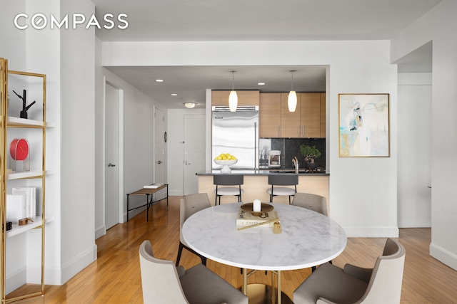 dining space with recessed lighting, baseboards, and light wood-style flooring