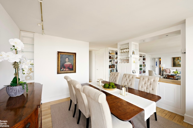 dining room with track lighting and light wood-style flooring