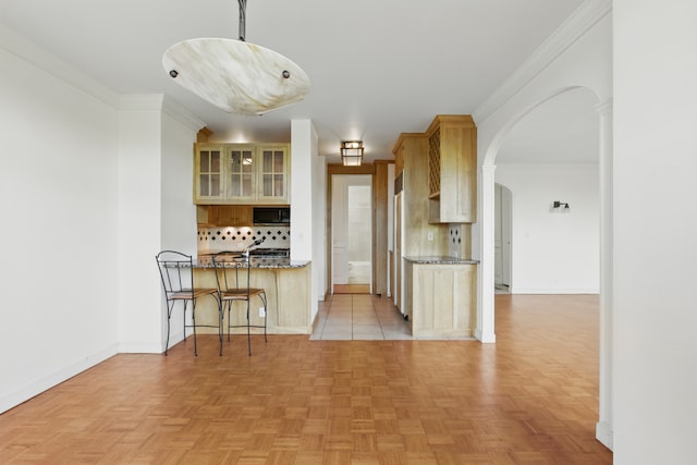 222 Riverside Dr Unit 5A, New York City, NY 10025 - kitchen featuring stainless steel microwave, arched walkways, tasteful backsplash, glass insert cabinets, and a kitchen breakfast bar