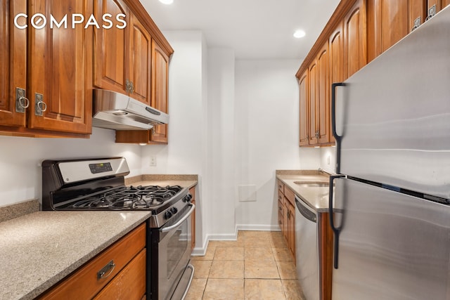 380 Riverside Dr Unit 7B, New York City, NY 10025 - kitchen featuring appliances with stainless steel finishes, under cabinet range hood, brown cabinets, and recessed lighting
