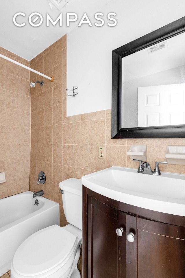 103A Patchen Ave, New York City, NY 11221 - full bathroom with vanity, toilet, shower / tub combination, and tile walls