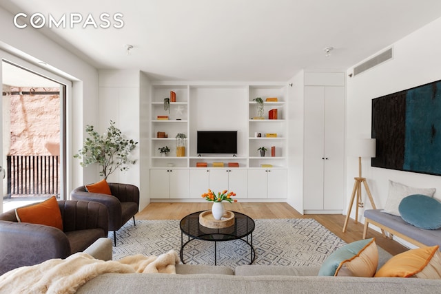 living room with light wood-type flooring and visible vents