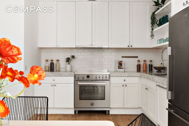 kitchen with light countertops, refrigerator, high end stainless steel range, and open shelves