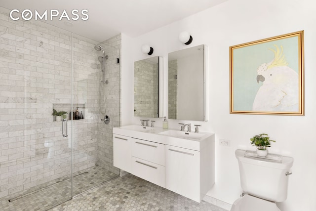 bathroom with a sink, a shower stall, and toilet