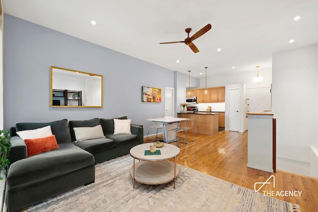 living area with recessed lighting, ceiling fan, and light wood-style flooring