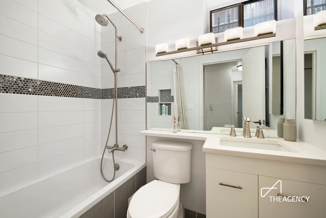 full bath with vanity, tiled shower / bath combo, and toilet