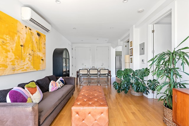 living room with arched walkways, recessed lighting, a wall mounted air conditioner, and wood finished floors