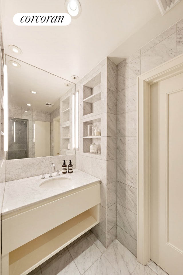 bathroom featuring vanity, marble finish flooring, a shower stall, and recessed lighting