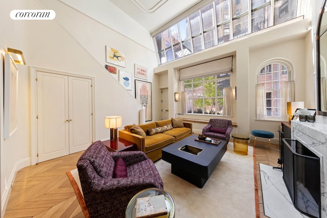 living room with a towering ceiling and baseboards