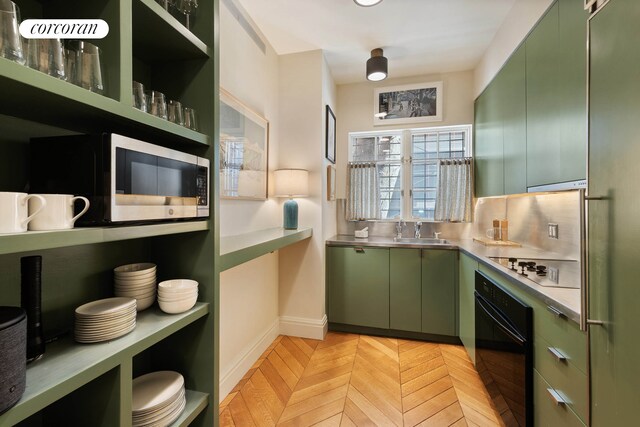 kitchen with stainless steel countertops, green cabinets, black appliances, open shelves, and a sink