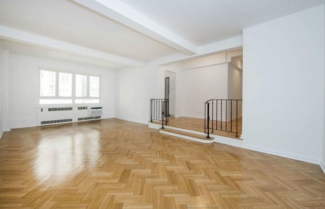 empty room with baseboards, a wall unit AC, stairway, and beamed ceiling