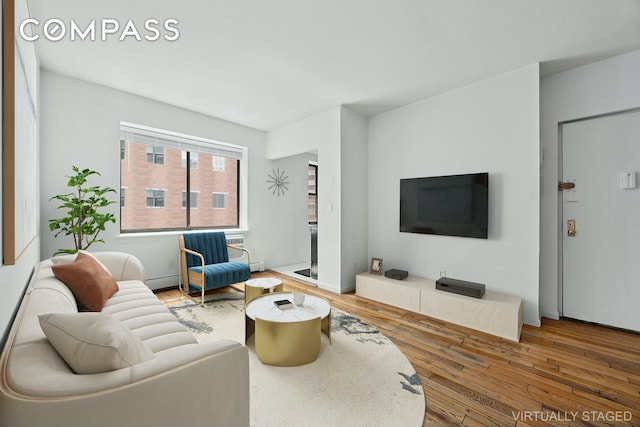 living area featuring baseboard heating and wood-type flooring