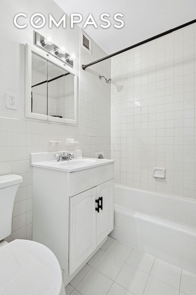 bathroom with visible vents, tile walls, tile patterned flooring, toilet, and  shower combination