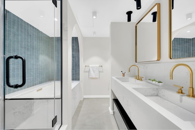 bathroom with tile patterned floors, a shower stall, double vanity, baseboards, and a bathtub