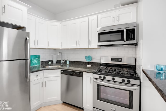520 E 72nd St Pha, Pha, New York City, NY 10021 - kitchen with stainless steel appliances, a sink, white cabinets, and dark stone counters