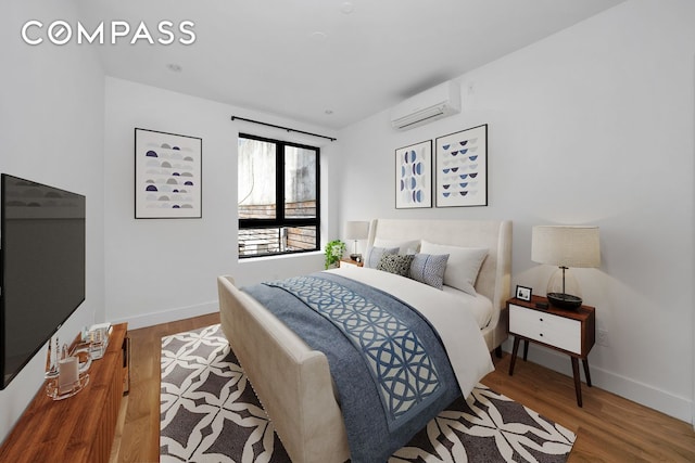 79 Clay St Unit 1R, New York City, NY 11222 - bedroom with an AC wall unit, wood finished floors, and baseboards