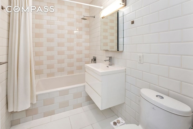 79 Clay St Unit 1R, New York City, NY 11222 - bathroom featuring toilet, tile walls, tiled shower / bath, vanity, and tile patterned flooring