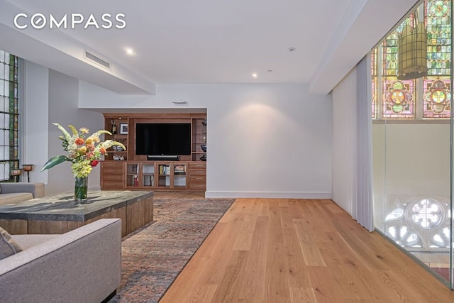 living area featuring wood finished floors, recessed lighting, and baseboards
