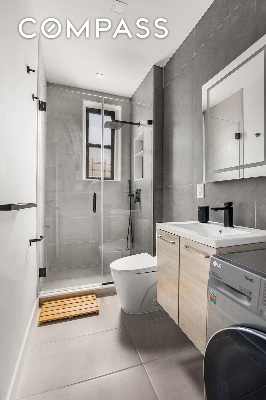 full bathroom featuring washer / dryer, tile patterned flooring, toilet, a shower stall, and vanity